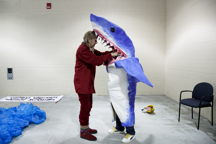 Multi-discipline New York artist Pat Oleszko, left, helps Osmar Ramos-Caballero of Holyoke with his costume of a BP employee being eaten by a shark. Oleszko has a costume-themed "Global Warning! Writhin' See/Change" group that will march in the annual First Night Grand Procession. ÒIÕm hard-hearted and a realist, but I have a functional sense of humor, so thatÕs how I deal with negativity,Ó Oleszko says. Participants for First Night prepared the day before New Year's Eve in Boston, MA on Sunday, December 30, 2012.