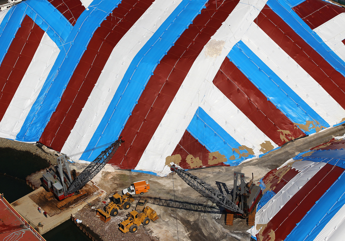 CHELSEA ,MA 04/ 18/ 2012 : SALT PILES under cover in red, white and blue tarps in Chelsea by the waterfront dwarf cranes and bulldozers which was hardly used from this past warm winter..
