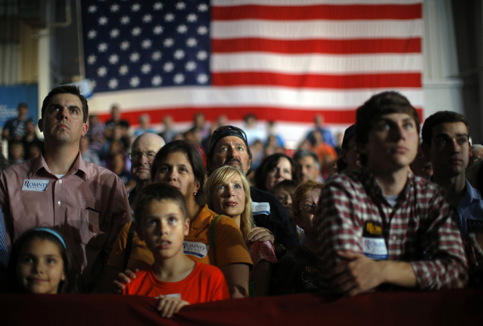 Audience members listen as Republican presidential nominee Mitt Romney speaks at a campaign rally in Cedar Rapids, Iowa October 24, 2012.