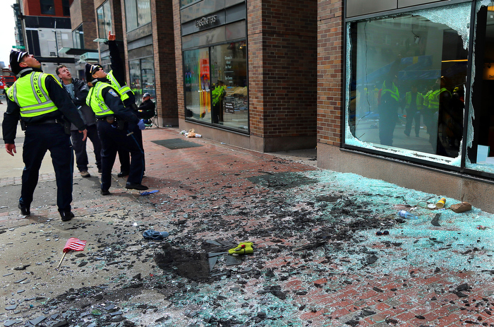 Boston-4/15/13- Boston Police officers look at blown out windows at the scene of the first terrorist bombing of the Boston Marathon on the sidewalk of Boylston Street.