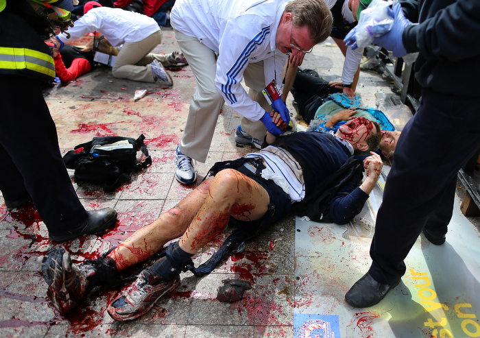 Boston-4/15/13 An injured man is comforted by a first responder on the sidewalk of Boylston Street at the site of the first Boston Marathon bombing.
