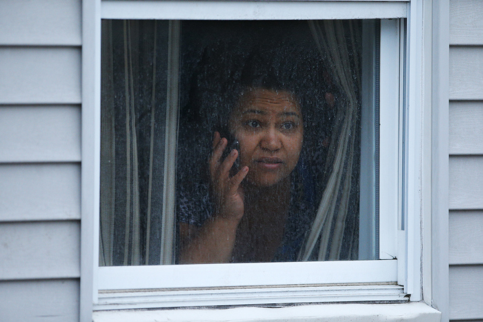 A woman watches police as they search for the Boston Marathon bombing suspects in Watertown, Massachusetts April 19, 2013. Police killed one suspect in the Boston Marathon bombing during a shootout and mounted a house-to-house search for a second man in the suburb of Watertown after a bloody night of shooting and explosions in the city's streets.
