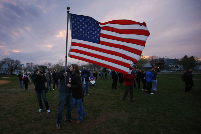 Neighbors hug under a U.S. flag as they arrive for a candle light vigil in the Dorchester neighborhood of Boston, Massachusetts April 16, 2013 where eight year-old Boston Marathon explosion victim Martin Richard lived. News reports say that Martin Richard was one of the victims of two explosions which hit the Boston Marathon on Monday killing at least three people and injuring over 100 others.