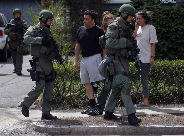 Residents watch as police officers search house to house for the second suspect in the Boston Marathon bombings in a neighborhood of Watertown, Massachusetts April 19, 2013. Two explosions hit the Boston Marathon as runners crossed the finish line killing at least three people and injuring over 100 others.