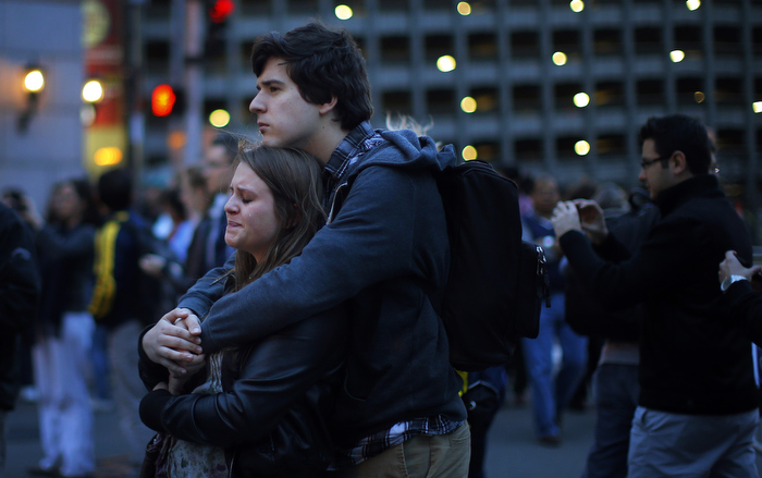 A woman cries in front of a memorial to the Boston Marathon bombings victims at the barricades surrounding the scene in Boston, Massachusetts April 18, 2013. Two explosions hit the Boston Marathon as runners crossed the finish line killing at least three people and injuring over 100 others.