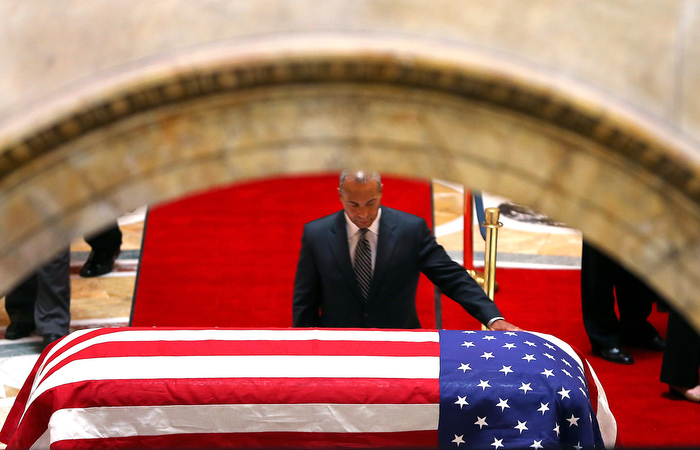 Boston-06/12313- A Remembrance for former Gov. Paul Cellucci was held at the State House House of Representatives, where friends, family and politicians attended. Gov. Deval Patrick places his hand on the casket in Memorial Hall as he led the line of dignitaries to visit the casket as it will lie in state for public viewing.