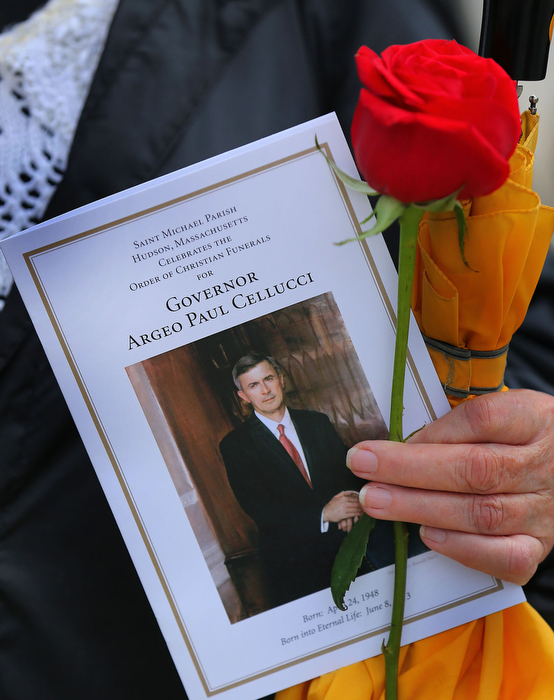 Hudson-06/14/13- A funeral mass was held at Saint Michael Church for former Gov. Paul Cellucci , where friends, family and politicians attended. A funeral program is held by a woman watching the funeral procession