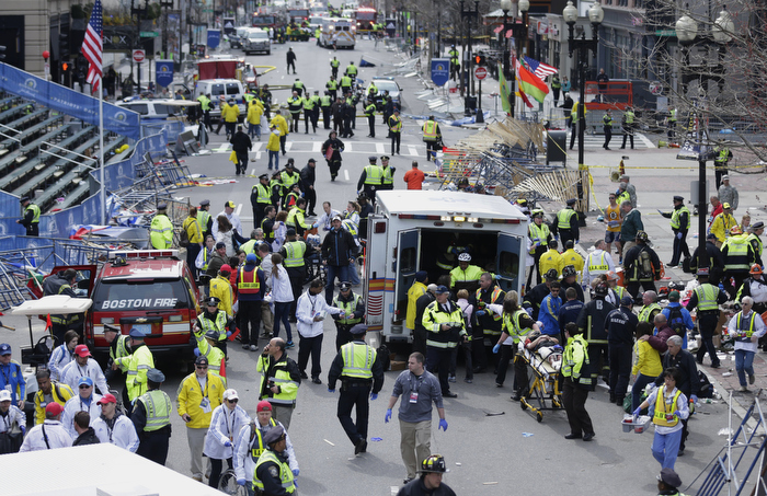 Medical workers aid injured people on Boylston Street at the finish line of the 2013 Boston Marathon following explosions in Boston, Monday, April 15, 2013.