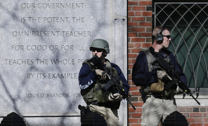U.S. Marshals in tactical gear stand guard outside Boston's Moakley Federal Court House after if was evacuated, Wednesday, April 17, 2013. The building was evacuated amid conflicting reports that a suspect in the Boston Marathon bombing was in custody and about to be brought into the court house.