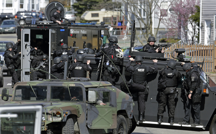 Tactical teams drive through a neighborhood while searching for a suspect in the Boston Marathon bombings in Watertown, Mass., Friday, April 19, 2013.