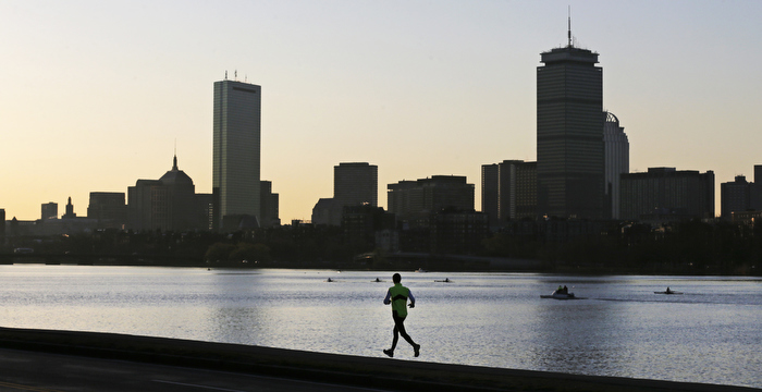 A solitary runner heads down the banks of the Charles River in Cambridge, Mass., in front of the Boston skyline, at dawn the morning after explosions killed three and injured more than 260 at the Boston Marathon, Tuesday, April 16, 2013.