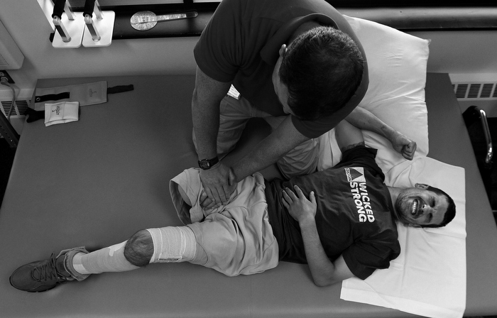 Marc winces in pain during a rehab session with physical therapist Sean Quinlan at the Spaulding Outpatient Center in Peabody. Marc reads in the paper that the lifetime cost of an above the knee prosthetic will be, minimum, $1.5 million. "I gotta get back to work, I gotta get going," he says. But he can't. Not yet. "I've got too much pain, too much medication," he says.