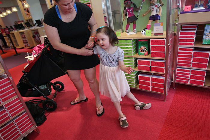 7. In June, Caroline and her mother have a shopping spree at the American Girl Doll store in Natick. Her troubling symptoms have returned--and Calle struggles for balance. The disease progressed almost daily. CarolineÕs left arm became clumsy and stopped working. Then her left leg. She started slurring her words, and facial expressions began to fade.
