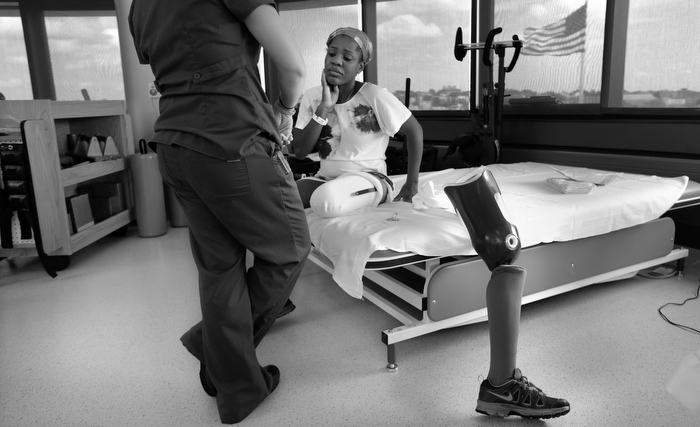 Mery Daniel, a Boston Marathon bombing survivor, pauses while she talks with her physical therapist Jessica Guilbert, as she takes a break from exercising with her new prosthetic leg, at Spaulding Rehabilitation Hospital, Wednesday, July 3, 2013, in Boston.