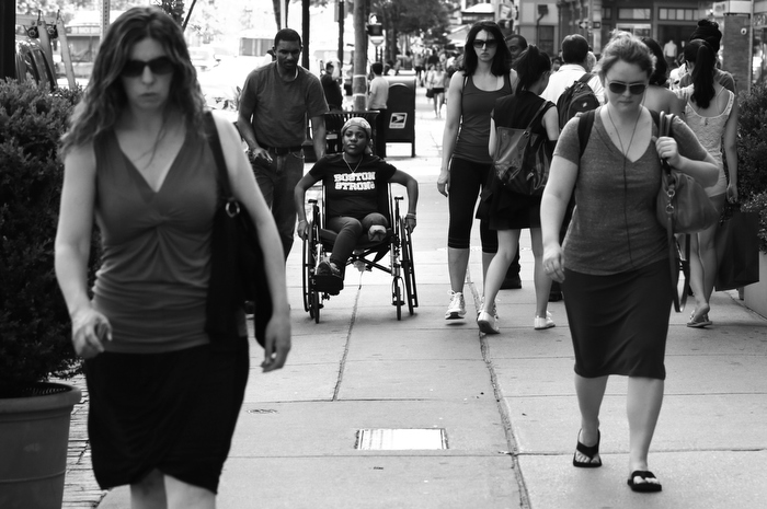 Mery Daniel, a Boston Marathon bombing survivor, heads down Boylston Street with her husband Richardson Daniel, after visiting the explosion site where she lost her left leg, Friday, May 31, 2013, in Boston. Daniel could no longer blend easily into a crowd of women out for an afternoon walk, but hoped to regain her independence to walk again.