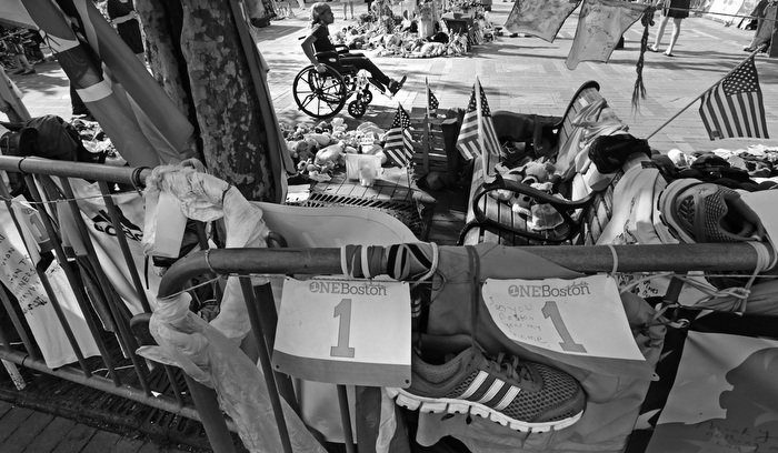 Mery Daniel, a Boston Marathon bombing survivor, wheels through a memorial for victims and survivors of the blast, at Copley Square near the race's finish line, Friday, May 31, 2013, in Boston.