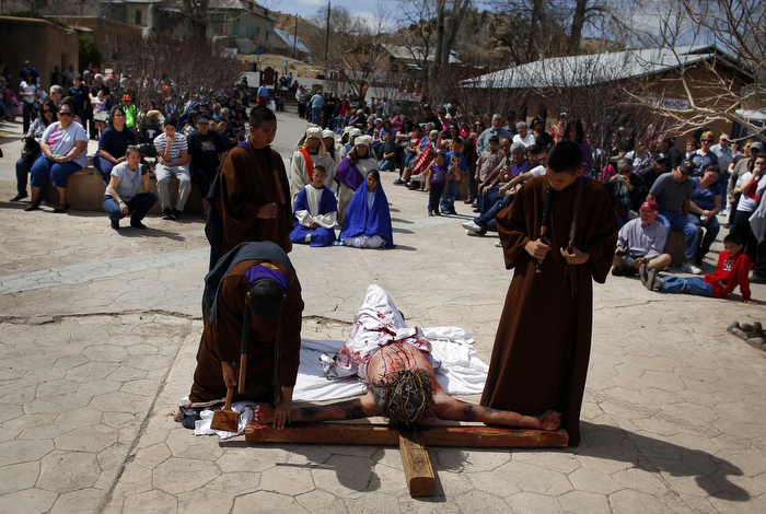 Students playing the roles of Roman soldiers place a man playing the role of Jesus (C) on a cross during a re-enactment of the Stations of the Cross at the Sanctuary of Chimayo in Chimayo, New Mexico March 28, 2013. The students are part of a youth group from Our Lady of Sorrows church in Bernalillo, New Mexico which re-enacts the Stations of the Cross every year.