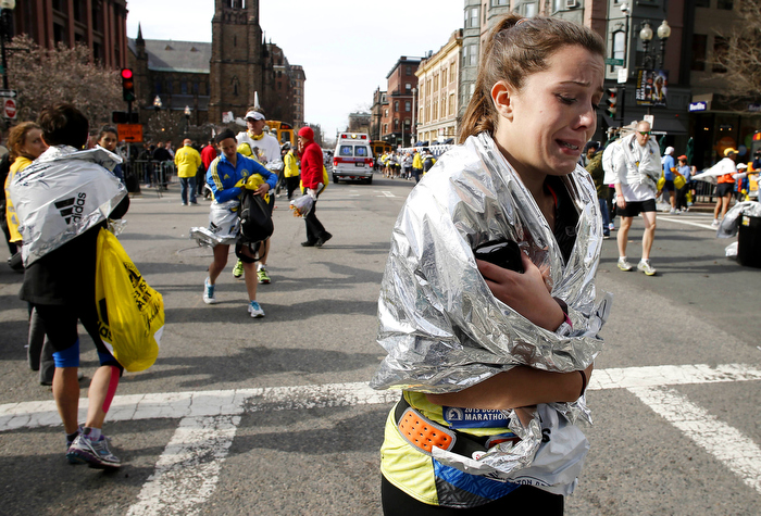 An unidentified Boston Marathon runner leaves the course crying near Copley Square in Boston Monday, April 15, 2013.