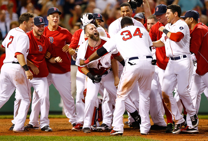 Mike Napoli #12 of the Boston Red Sox is congratulated by teammates at home plate after hitting a walk-off home run in the 11th inning against the New York Yankees during the game on July 22, 2013 at Fenway Park in Boston, Massachusetts.