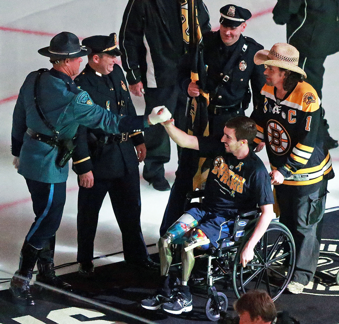 Boston Marathon bombing victim Jeff Bauman and Carlos Arredondo, the man who wheeled him to medical attention after he lost both legs in the blast are greeted by first responders as they leave the ice following a pre game flag waving. The Boston Bruins hosted the Chicago Blackhawks for Game Six of the Stanley Cup Finals at the TD Garden.