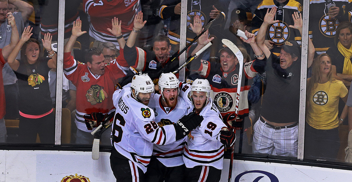 With less than 90 seconds left in the game, and the Blackhawks down by a goal, Chicago's Bryan Bickell (center) beat Bruins goalie Tuukka Rask to tie the game at 2-2