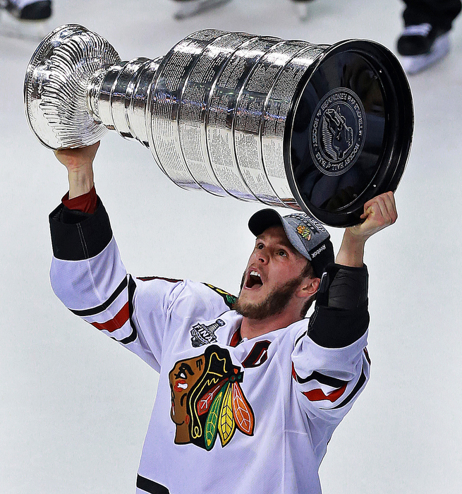 Blackhawks captain Jonathan Toews is the first to hoist the Stanley Cup following his team's dramatic victory.