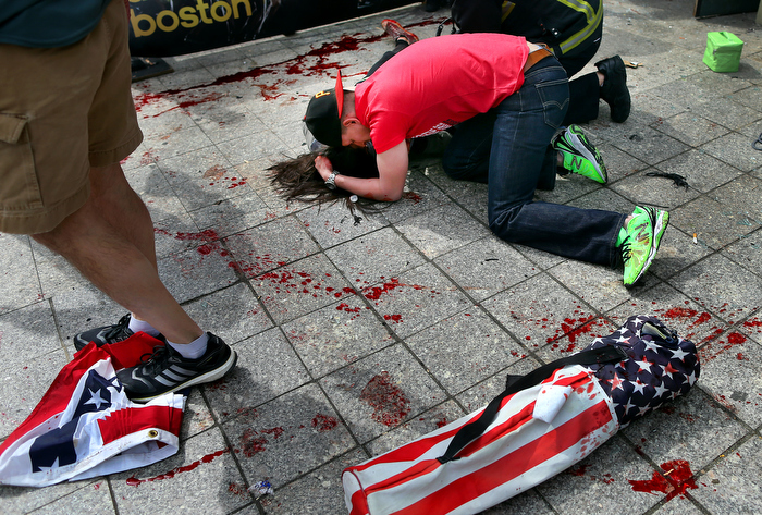 Boston-4/15/13- Joe,Duncan, a Marine comforts a woman who was hit by shrapnel from the first terrorist bomb on the sidewalk near he finish line of Boylston Street.