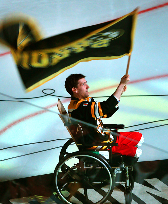 Boston-5/04/13-Boston Marathon bombing survivor Jeffrey Bauman waves a Bruins flag before the start of the Bruins vs Toronto Maple Leaf quarterfinal playoff game. He lost both legs in the bombing. He lost both legs in the bombing.