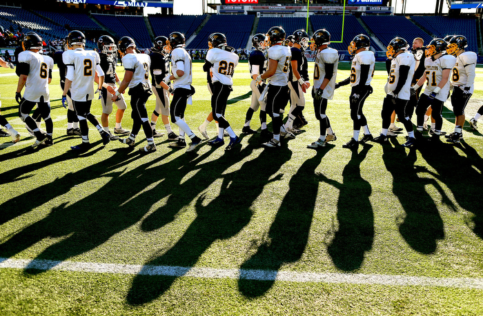 Foxborough12/07/13- The shadows of Cohasset and Littleton football players shaking hands are cast on the field at the end of the game in which Littleton won the Super Bowl.