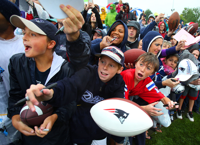 Foxborough-07/26/13 _ The New England Patriots held their first day of training camp at the practice field at Gillette Stadium. Fans scream for autographs as Tom Brady approaches at the end of the camp.