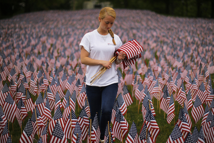 Shannon Day, a volunteer with Massachusetts Military Heroes Fund, replaces broken flags at a Memorial Day display of United States flags on the Boston Common in Boston, Massachusetts May 23, 2013. According to the Massachusetts Military Heroes Fund, the flags are planted on the Common for fallen Massachusetts service members at the Memorial Day holiday, which will be celebrated May 27 in the U.S.