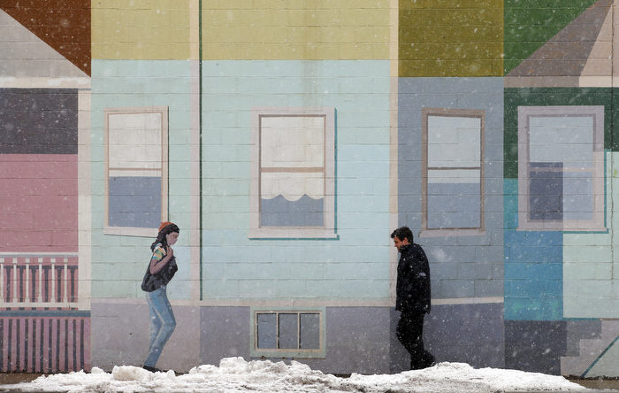 A pedestrian walks past a mural at the beginning of a winter storm in Somerville, Massachusetts March 7, 2013.