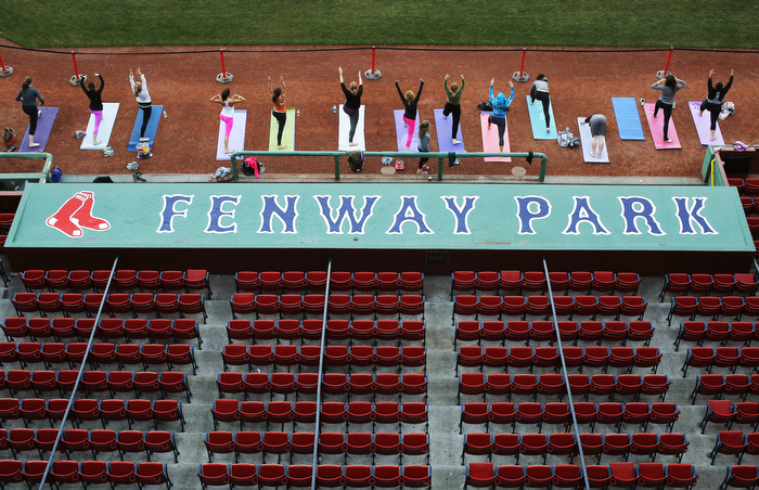 Participants take part in the first ever public yoga session at Fenway Park, home of MLB's Boston Red Sox, in Boston, Massachusetts September 23, 2013. Money raised by the Fenway Yoga session benefited two of the Boston Red Sox foundation's cornerstone programs, the Red Sox Scholars Program and the RBI Youth Baseball and Softball Programs.