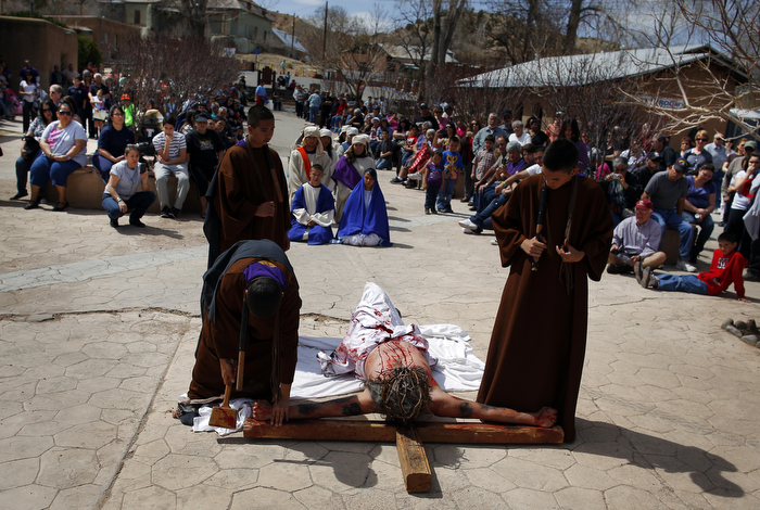 Students playing the roles of Roman soldiers place a man playing the role of Jesus (C) on a cross during a re-enactment of the Stations of the Cross at the Sanctuary of Chimayo in Chimayo, New Mexico March 28, 2013. The students are part of a youth group from Our Lady of Sorrows church in Bernalillo, New Mexico which re-enacts the Stations of the Cross every year.