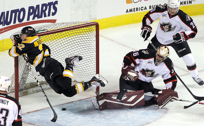 David Pastrnak, left, of the Providence Bruins, goes flying into the cross bar of Providence's goal as Portland goaltender Mike McKenna and defenseman Patrick McNeill, at right, look on during Portland's home opener at the Cross Insurance Arena Saturday, October 11, 2014. There was no goal on the play.