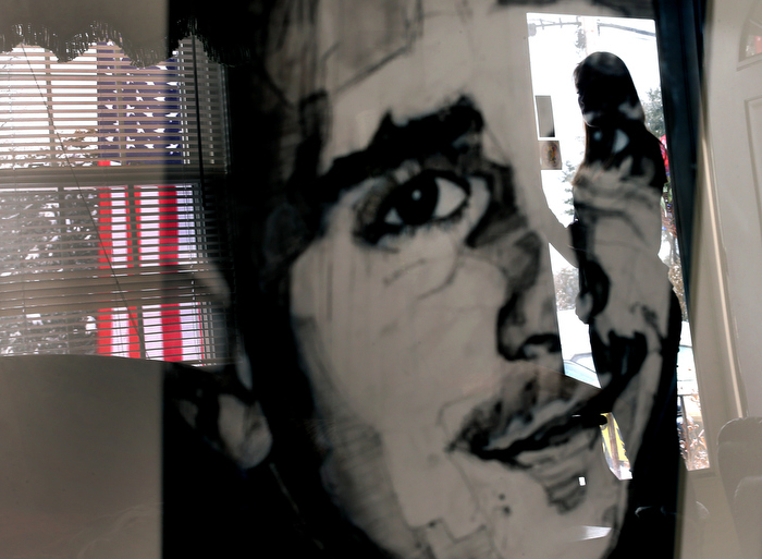 Abington- 02/06/14- Marine Sgt. Danny Vasselian from Abington was killed in Afghanistan in late December. His widow Erin reflected on her loss as she went through his possessions. A portrait of him that a friend drew sits on a table in her living room reflecting her in the front door, as an American flag hangs outside the house.
