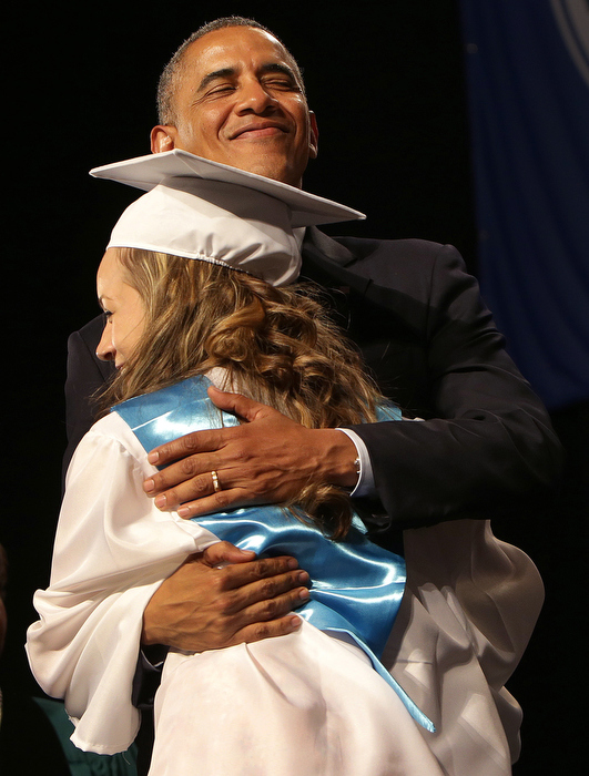 President Obama hugs a graduate during Commencement ceremonies inside the DCU center. President Obama was the featured guest speaker at Worcester Technical High School's graduation at the DCU Center in Worcester, MA. Worcester Technical High was lauded for transforming from the lowest performing school in the city and one of the lowest performing vocational schools in the state to a 2013 U.S. Department of Education Blue Ribbon School.