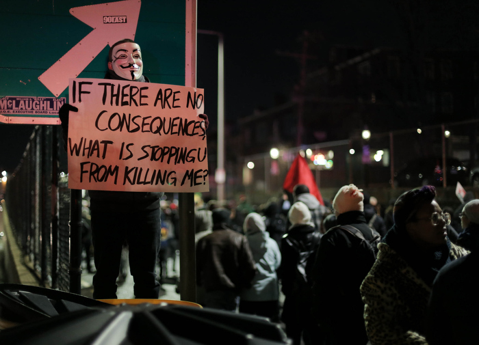 Boston. Dec. 4, 2014. A protestor wears a Guy Fawkes mask as protestors march on Boston streets on Thursday night.