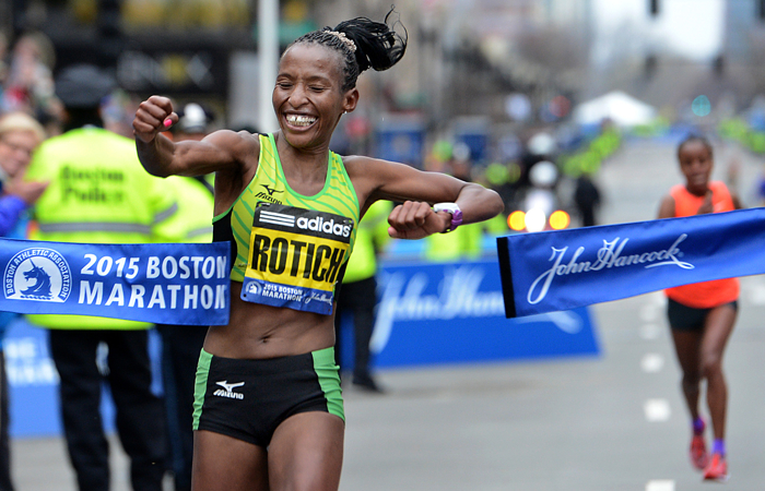 Caroline Rotich of Kenya punches through the tape to win the women's division of the 2015 Boston Marathon. Mare Dibaba of Ethiopica, right, was just four seconds behind in second place.