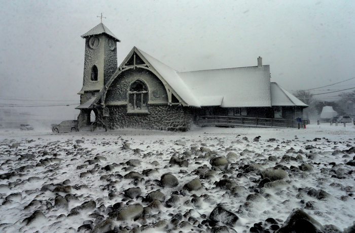 Marshfield-1/27/2015 The Victory Baptist Church in Brant Rock across the street from the ocean, is covered in snow and ice as another band of heavy snow hits the area. Homes along the shore of Brant Rock on the ocean are destroyed by the force of the ocean during the blizzard. Large rocks have filled the parking lot from the ocean.