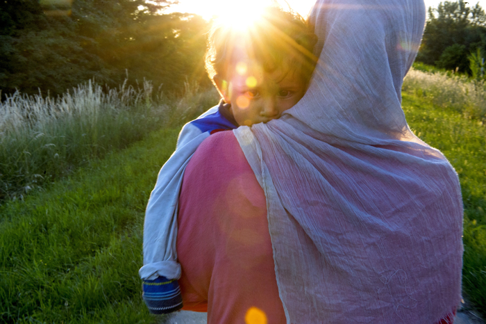 Fatheya carries her son Abdullah while traveling with other Syrian refugees on a path near the Hungarian border on June 2, 2015 in Kanjiža, Serbia. The group walked several miles along the Tisza river at sunset to pass through the border with Hungary at night to avoid the police. Refugees seeking asylum rushed through the Serbo-Hungarian border before Hungary erected a border fence.