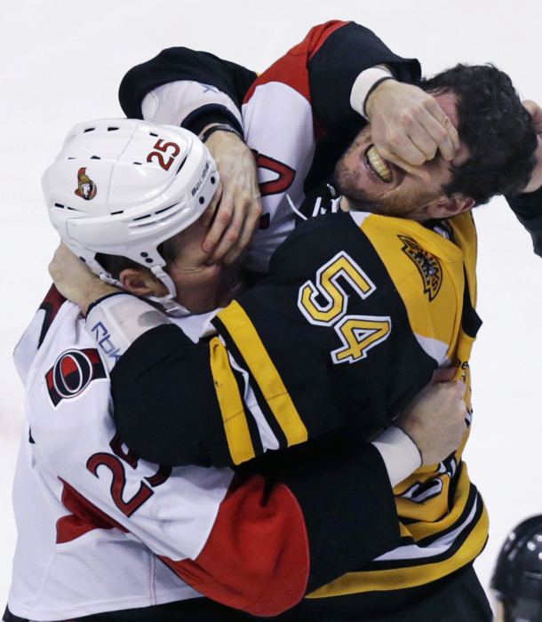 Ottawa Senators right wing Chris Neil and Boston Bruins defenseman Adam McQuaid gouge each other's eyes as they fight.