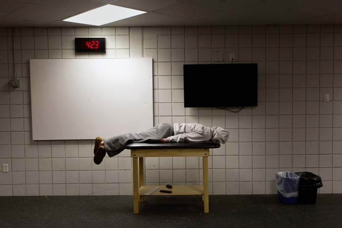 Ryley Austin of Lisbon, a sophomore at Mt. Ararat High School, rests on a trainer's table in the locker room at Watson Arena in Brunswick at 4:23 a.m. before the start of his hockey team's practice at 4:55 Tuesday, January 13, 2015. Mt. Ararat is one of many teams in Southern Maine who must practice at odd hours because of a shortage of hockey rinks.