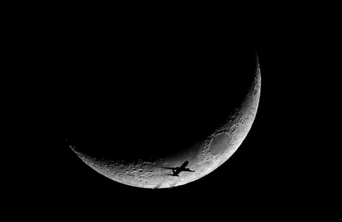 01/23/15-Boston,MA A high altitude jet exits the U.S. East Coast, in front of a crescent moon. Flight tracking software found this to be an Austrian Air Boeing 767, flying from JFK, New York to Austria.