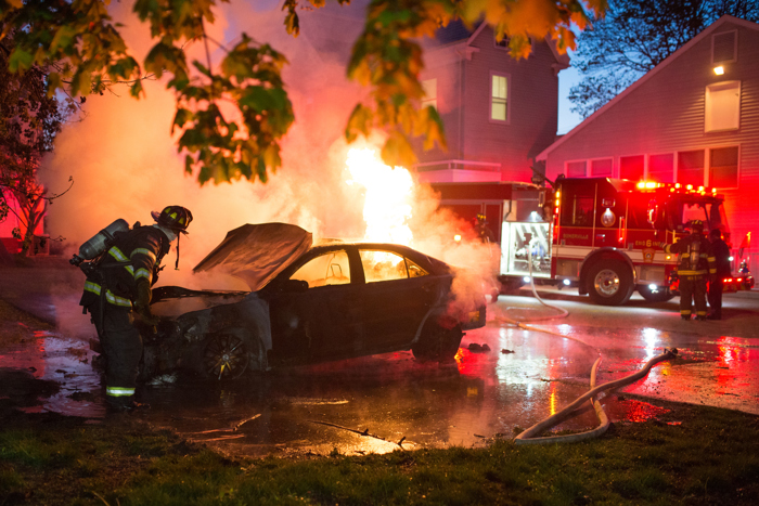 Firefighters extinguish a car fire in the parking lot of Health Service on Monday, May 9, 2016. The fire accompanied bomb threats which caused cancellations of final exams campus-wide.